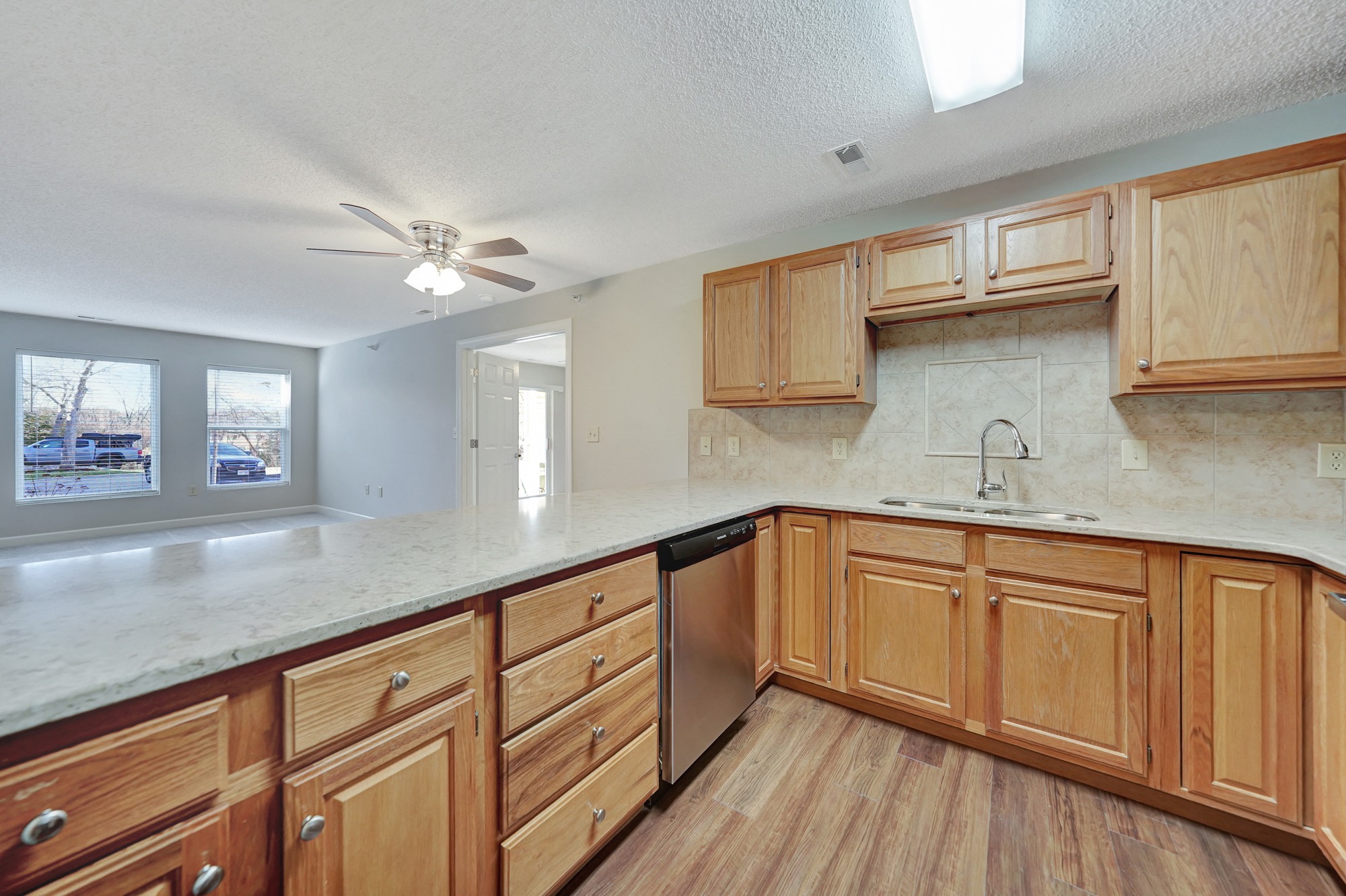 an empty kitchen with wooden cabinets and a counter top